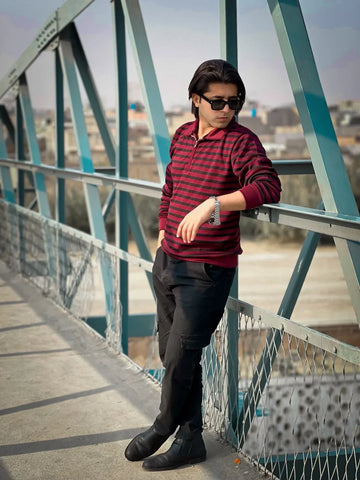 Fashion influencer wearing maroon colorblock half-zip sweatshirt on a bridge outdoor photoshoot